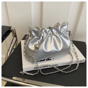 Detail view of silver pleated bucket bag with metallic chain strap and ball charm