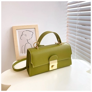 Close-up of avocado green leather bag featuring a polished gold square buckle lock detail