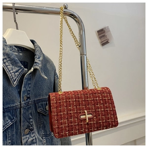 Detail of red tweed plaid crossbody bag with golden chain and oval twist lock clasp