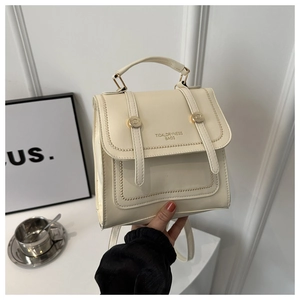 Close-up of off-white faux leather backpack with dual straps and gold metal buckle detail