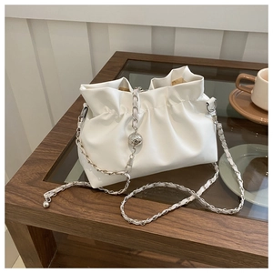 Detail of white pleated cloud bag featuring silver chain strap with adjustable metal ball
