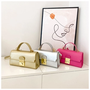 Detailed view of mini square crossbody bags in metallic gold, silver, and rose pink finishes
