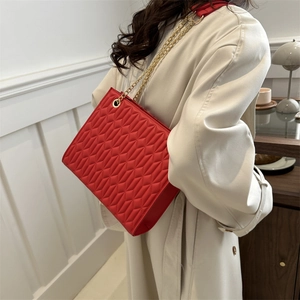 Chic red quilted shoulder bag with gold chain strap for elegant commuting outfits