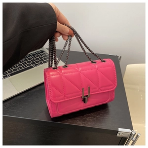 Detail of rose red quilted crossbody bag with metal chain strap and twist lock
