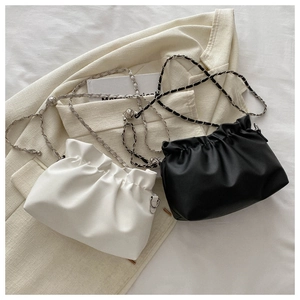 Detail of white and black pleated bucket bags with silver chain and metal ball charms