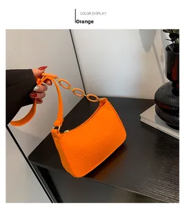 Detail der orangefarbenen Tasche mit Krokodilmuster, Gold-Reißverschluss und Kunststoffkette
