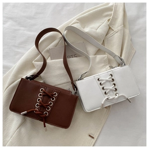 Détail de sacs portés épaule en similicuir avec laçage croisé et œillets métalliques
