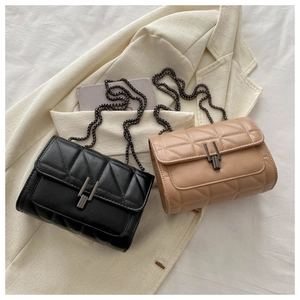 Close-up of quilted crossbody bags in black and beige with metallic chain straps