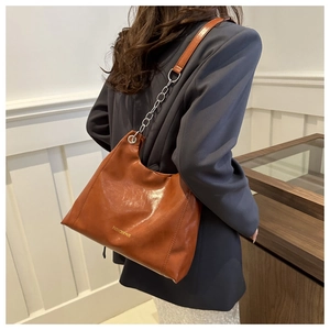 Caramel oil wax leather shoulder bag detail with metal chain strap and logo