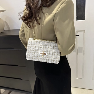 Elegant white tweed flap bag with gold chain strap and metallic oval turn-lock closure