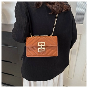 Close-up of vintage brown crossbody bag with V-shaped quilting and gold chain strap