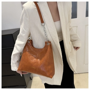Dettaglio della borsa hobo caramello con catena argentata e texture in pelle fine