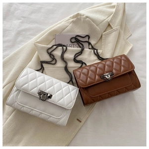 Close-up of quilted pattern and hardware on beige and brown chain strap handbags