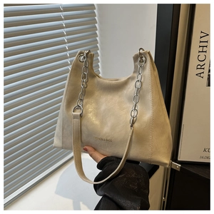 Dettaglio della trama in ecopelle bianco crema e della tracolla a catena della borsa