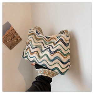 Gros plan d'un sac cabas tissé avec motifs de vagues bleues et vertes et bandoulière