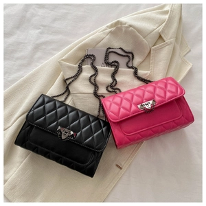 Close-up of quilted crossbody bags with chain straps and metallic lock detail on blazer