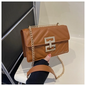 Detailed view of brown quilted leather bag with gold chain strap and metal clasp