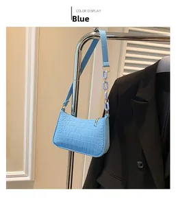 Details der blauen Tasche mit Krokodilmuster, Goldkette und breitem Schultergurt