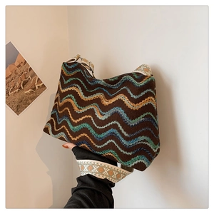 Détail d'un sac cabas en tricot ethnique aux motifs colorés et large bandoulière brodée
