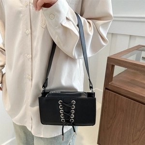 Sac sous l'aisselle tendance en cuir verni noir avec lacets et œillets argentés