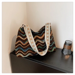 Détail du sac bohème en tricot avec broderie ondulée et large bandoulière jacquard