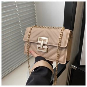 Close-up of beige quilted crossbody bag with vintage gold clasp and chain strap