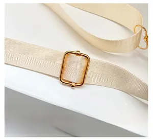 Detail of beige quilted backpack with smooth adjustable straps and gold metal hardware