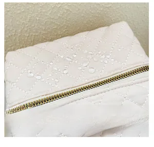 Detail of waterproof quilted oxford fabric with water droplets and golden metal zipper