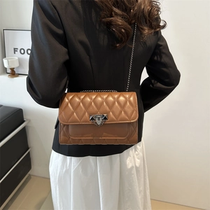 Brown quilted crossbody bag with diamond stitching and geometric metal lock detail