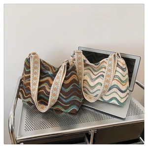 Détail de sacs cabas en tricot bohème avec motifs à vagues et larges bandoulières ethniques