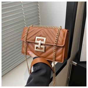 Close-up of caramel brown chevron quilted bag with golden chain and geometric lock