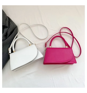 Detail of white and rose red trapezoid handbags with asymmetric flaps and gold hardware