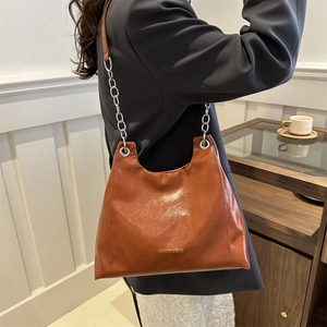 Brown oil wax leather shoulder bag with thick silver chain and minimalist tote design