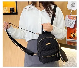 Detail of black quilted oxford cloth mini backpack with a matching round coin purse pendant