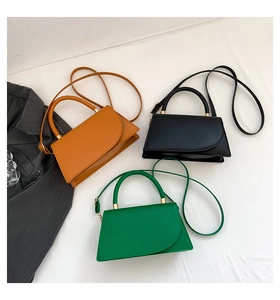 Minimalist asymmetrical flap handbags in orange, black, and green with cylindrical handles