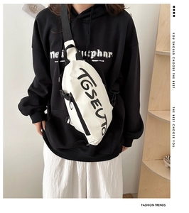 Détail d'un sac bandoulière blanc avec impression de lettres noires en style urbain