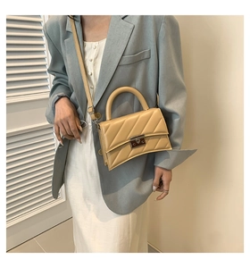 Petit sac carré beige matelassé avec fermoir argenté porté par un mannequin