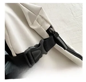 Détail de la boucle noire robuste et de la fermeture éclair sur le sac en nylon blanc
