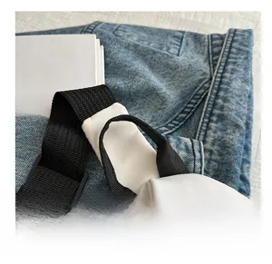 Détail du sac de poitrine en nylon blanc avec poignée tissée noire et coutures renforcées