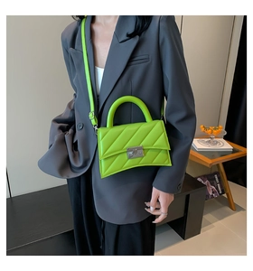 Détail du sac à main matelassé vert citron avec fermoir argenté et base incurvée