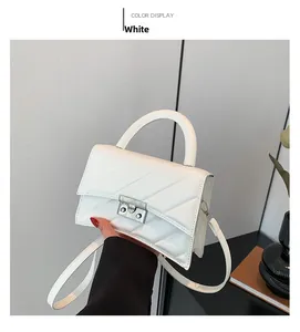 Détail du sac à main matelassé blanc avec fermoir argenté et bandoulière réglable