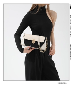 Detail showing the crocodile texture, metal chain, and round lock of the colorblock bag