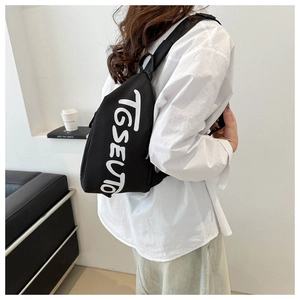 Gros plan d'un sac de poitrine noir avec imprimé graphique blanc TGSEUTO sur modèle