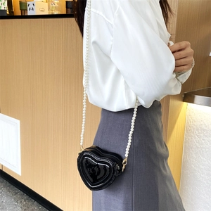 Bolso bandolera negro brillante en forma de corazón con elegante correa de perlas