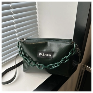 Detail of dark green glossy handbag featuring a thick chain strap and Fashion label
