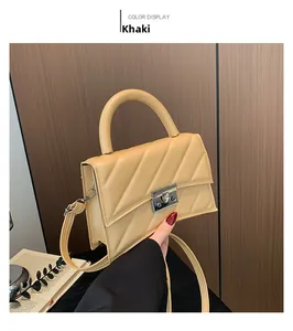 Détail du sac en cuir kaki avec surpiqûres en V et fermoir rotatif carré en métal argenté