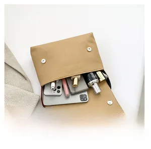 Spacious interior of khaki leather crossbody bag showing capacity for phones and cosmetics