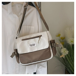 Détail du sac messager bicolore avec rabat blanc et bandoulière en nylon réglable