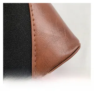 Close-up of black suede and brown leather patchwork with precision stitching details