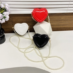 Bolsos bandolera de charol en forma de corazón en rojo, blanco y negro con correa de perlas